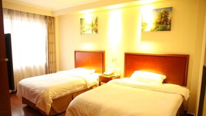 A hotel room with two beds, a nightstand, a lamp, and a window with curtains. - Greentree Inn Heze Juye West No.1 Middle School Hotel (Heze)