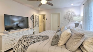 A bedroom with a bed, a TV, a ceiling fan, and a dresser. - Renovated Cottage w/ Fire Pit in Munds Park! (Munds Park)