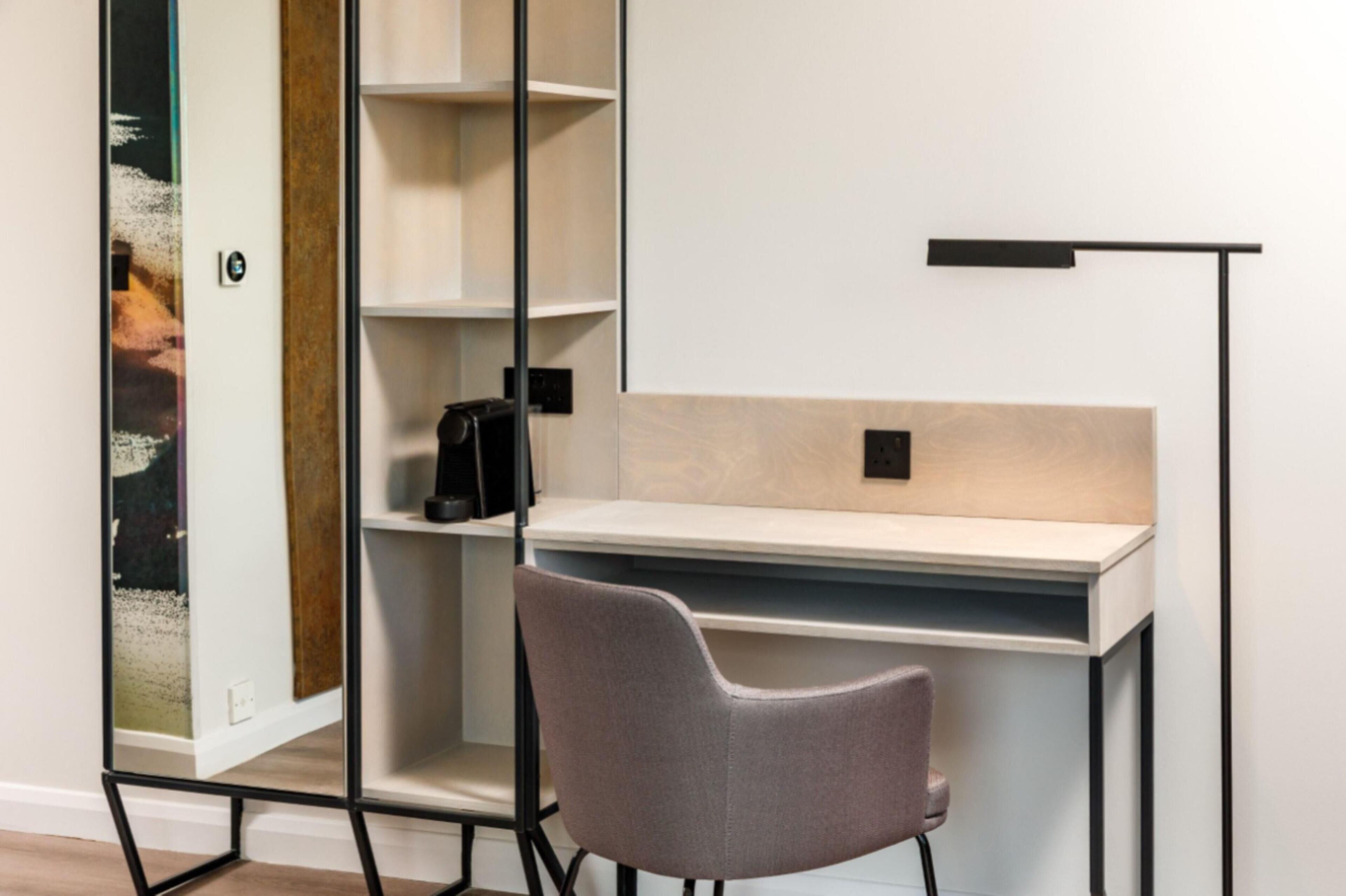 Un espace de bureau moderne comprenant un bureau, une chaise et une étagère.