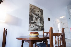 Ein Essbereich mit Tisch, Stühlen und einem großen gerahmten Kunstwerk an der Wand.