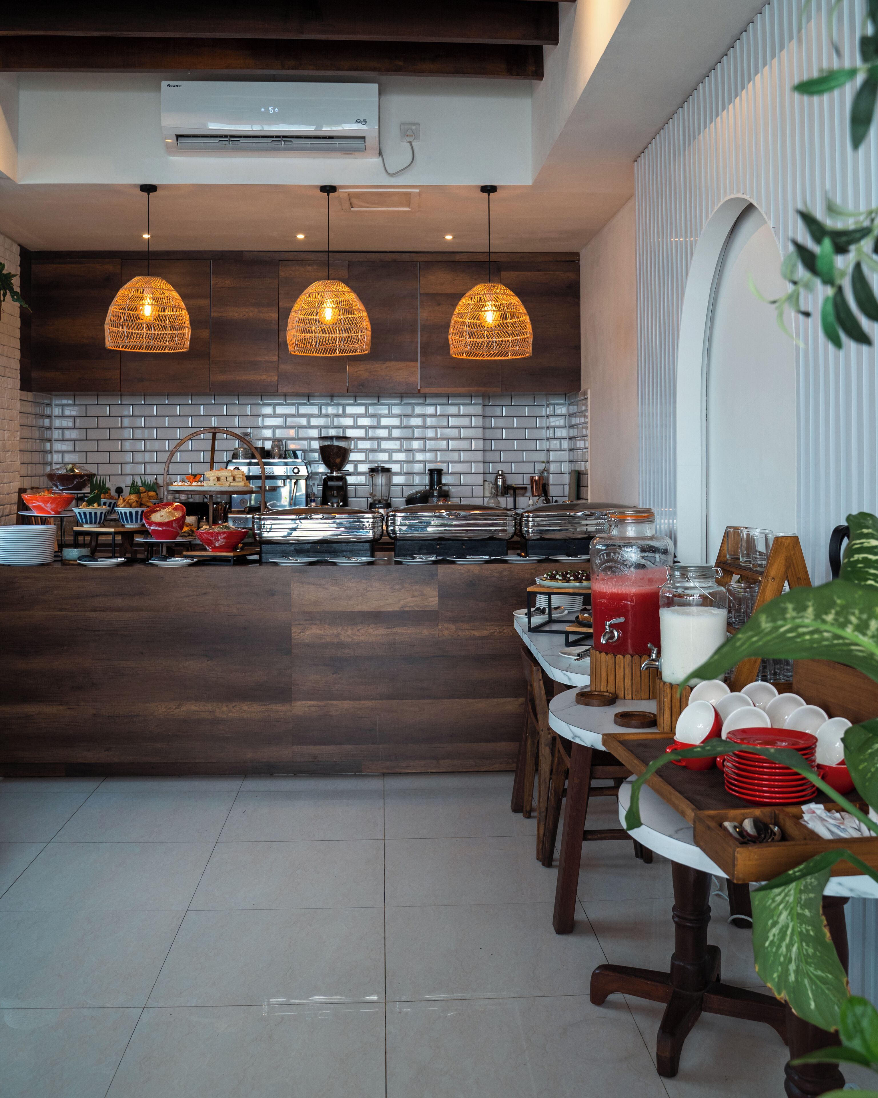 A modern kitchen with a central island, pendant lighting, and a buffet setup.