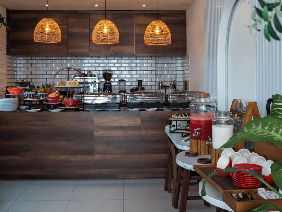 A modern kitchen with a central island, pendant lighting, and a buffet setup.