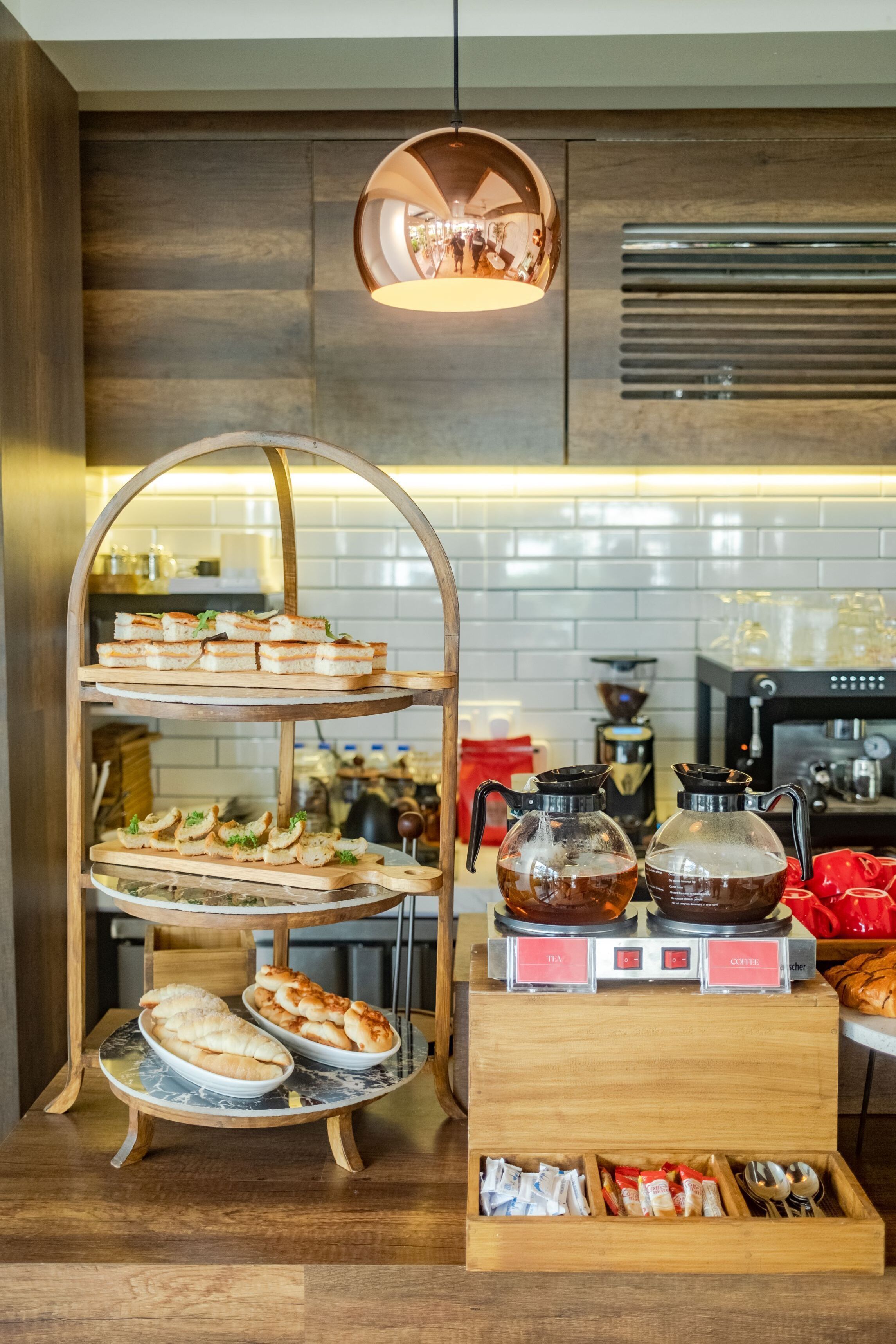 A breakfast buffet with multiple serving options, including pastries and sandwiches, and a coffee station with brewing equipment.
