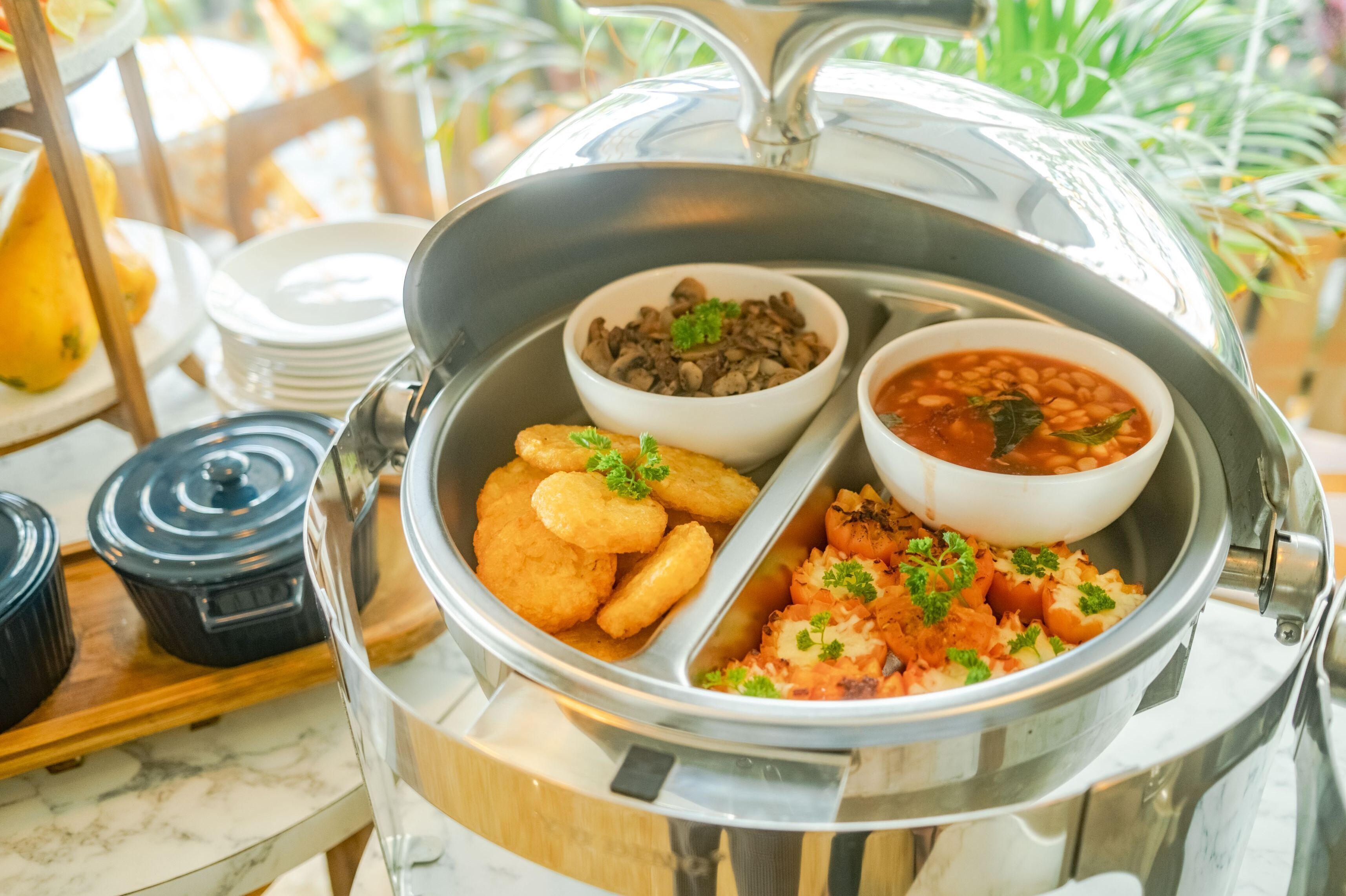 A buffet with various dishes including beans, fried items, and rice garnished with herbs.