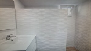 A bathroom with a sink, mirror, and shower area. - Apartment in Tenerife South (Cabo Blanco - Arona)