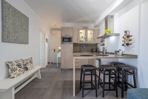 Une cuisine moderne dotée d’un îlot central, de tabourets de bar, d’un four à micro-ondes et d’un meuble à vin.