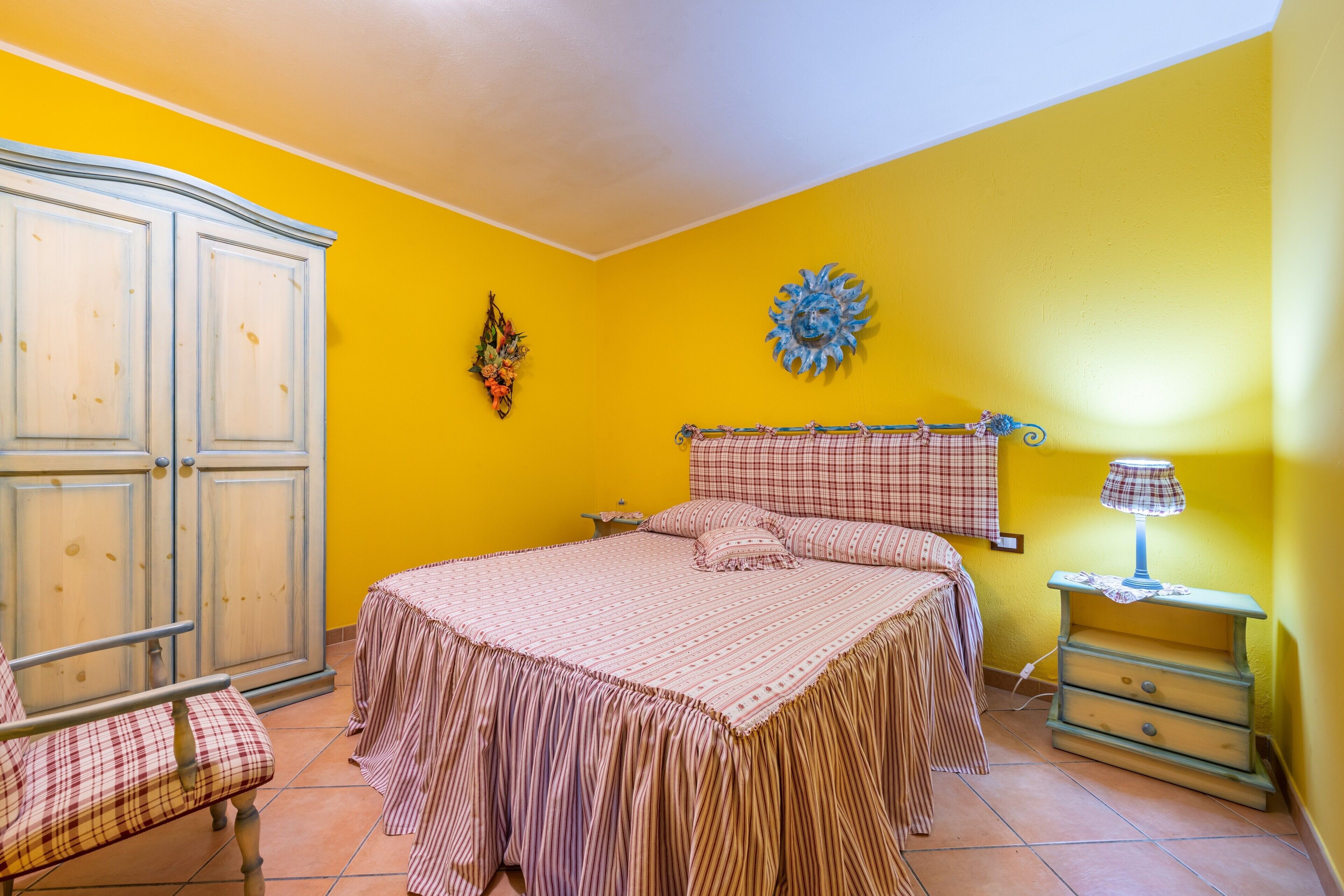 Un dormitorio con cama, mesita de noche, silla y armario.