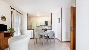 Una cocina moderna con zona de comedor, una bañera blanca y un armario de madera.