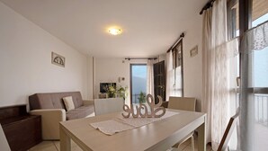 Un espace repas comprenant une table, des chaises, un canapé et une vue sur l’extérieur.
