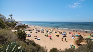 A beach with umbrellas, people, and a building in the background. - Ocean View Apartment with Sea View, Wi-Fi (Armação de Pêra)