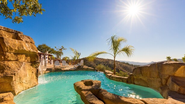 A natural pool surrounded by rock formations, with a clear view of the landscape and a sunlit sky. - Pet-Friendly Vacation Home 'Miramar' with Garden, Private Pool, Terrace & Wi-Fi (Almogia)