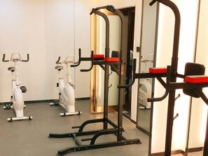 Een sportschool met fitnessapparatuur, waaronder loopbanden en een krachttrainingapparaat.