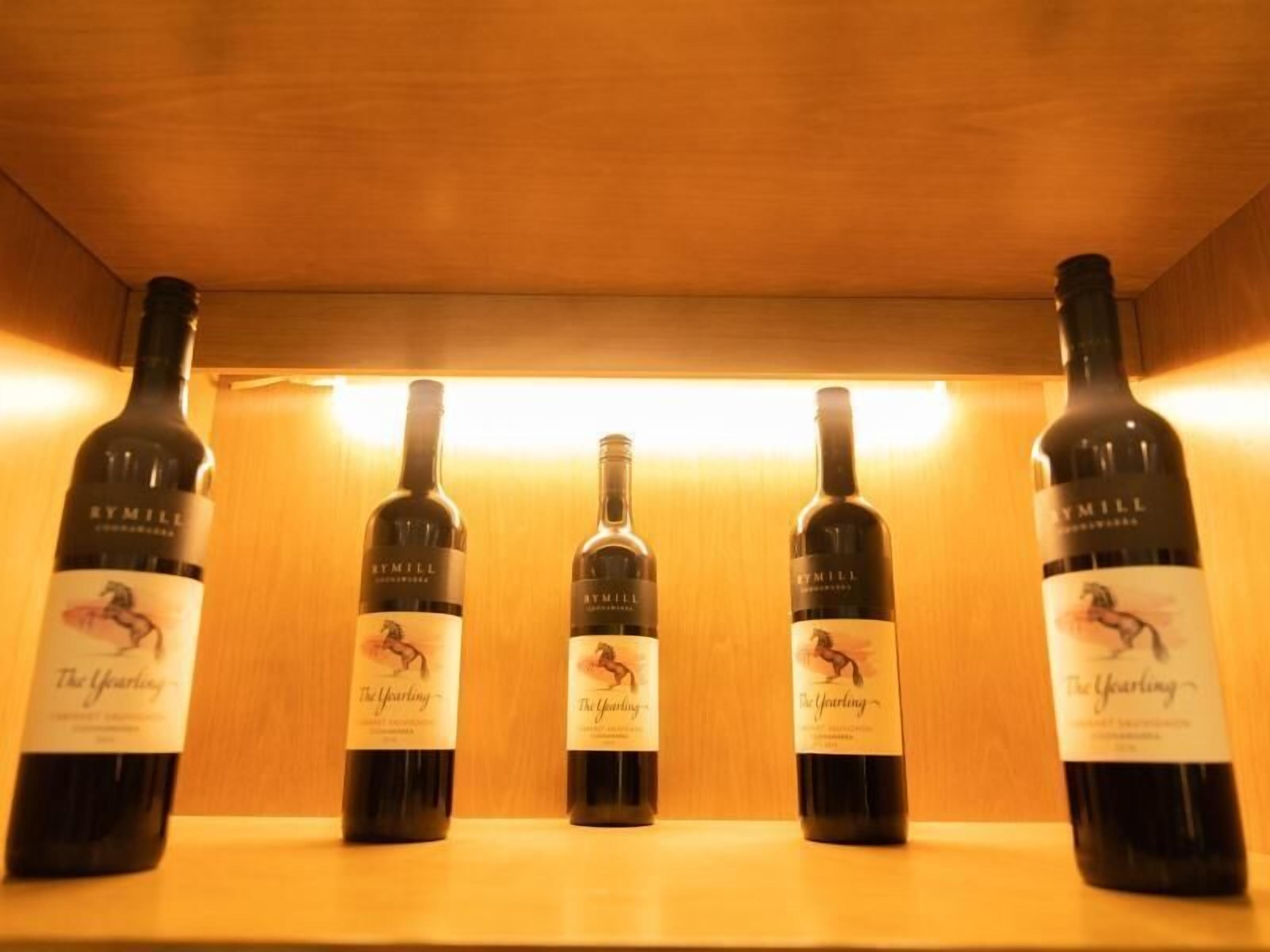 A wooden shelf with five bottles of wine labeled "The Yearting" by Rymill.