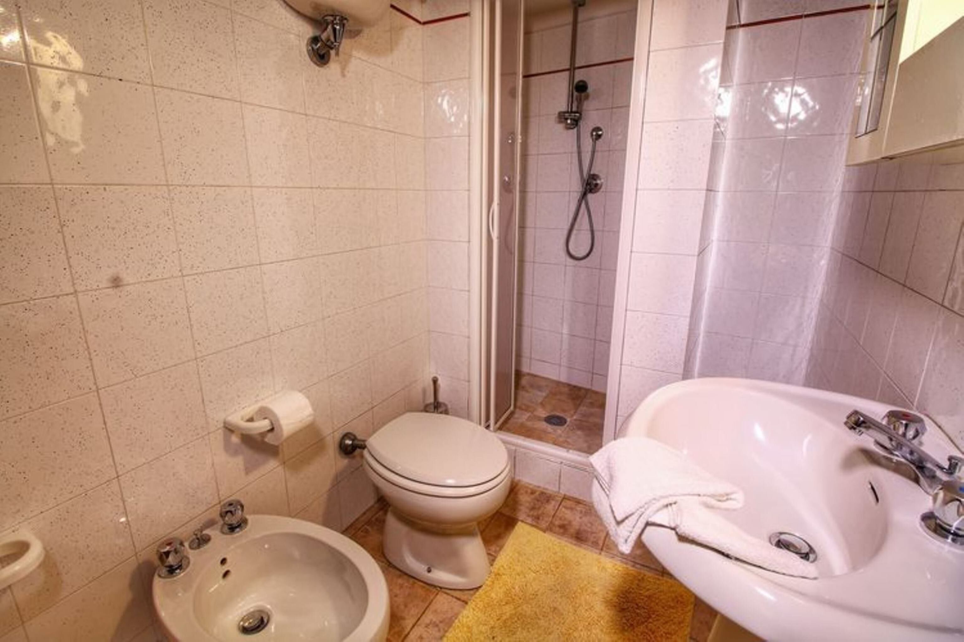 Kylpyhuone, jossa on wc, bidee, pesuallas ja suihku.