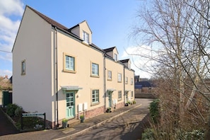 A row of two-story buildings with a sign reading 'St. Thomas Mews.' - Townhouse with Views of Wells Cathedral (Wells)