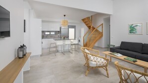 Un espace de vie moderne comprenant une cuisine, un coin repas et un escalier.