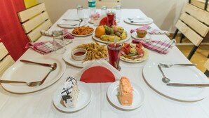 Una mesa de comedor dispuesta con platos de comida, cubiertos y una botella de agua.