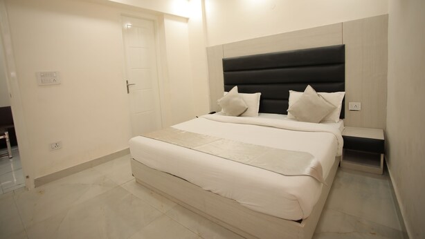 Un dormitorio moderno con una cama grande, una mesita de noche y un cabecero.
