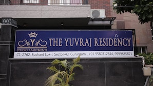 Letrero de The Yuvraj Residency, Departamentos tipo estudio, con información de contacto y dirección.