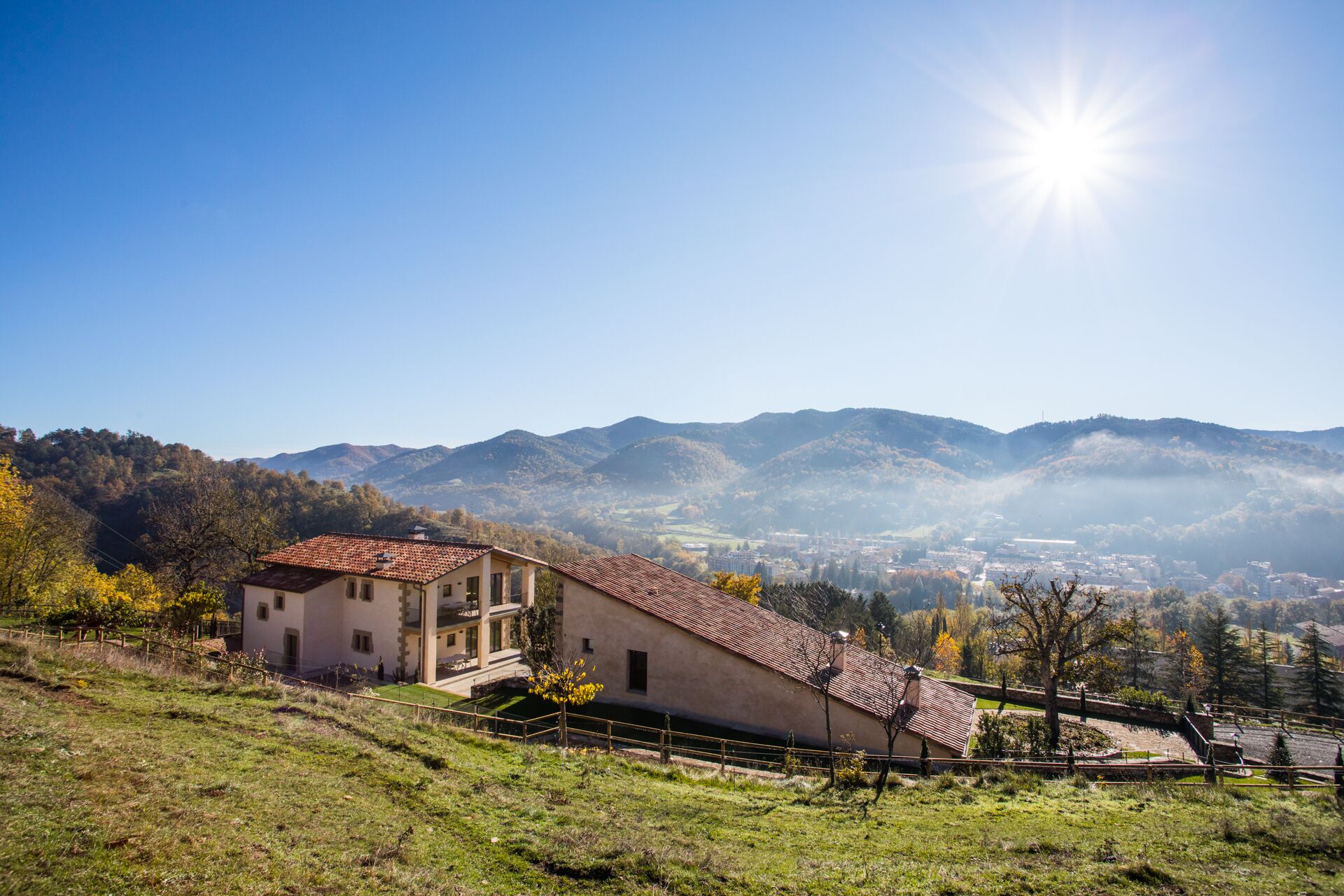 A house with a sloped roof, a small porch, and a view of a valley and distant town.