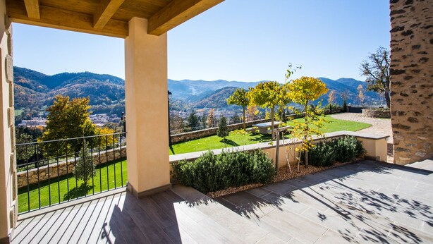 A covered outdoor area with a view of a mountainous landscape.