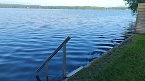 Un lac paisible, avec une jetée en bois qui s’avance sur l’eau.