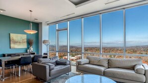 A spacious living room with a large window offering a panoramic view of the cityscape.