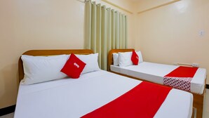 A hotel room with two beds, each with white bedding and red accents, a wooden headboard, and a window with curtains. - OYO 836 E & H Residences (Parañaque)
