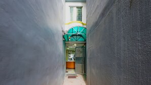 A narrow corridor with a reception desk and a green awning. - OYO 836 E & H Residences (Parañaque)