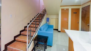 A staircase with metal railings, a blue sofa, a white counter, and a door labeled "Authorized Personnel Only". - OYO 836 E & H Residences (Parañaque)