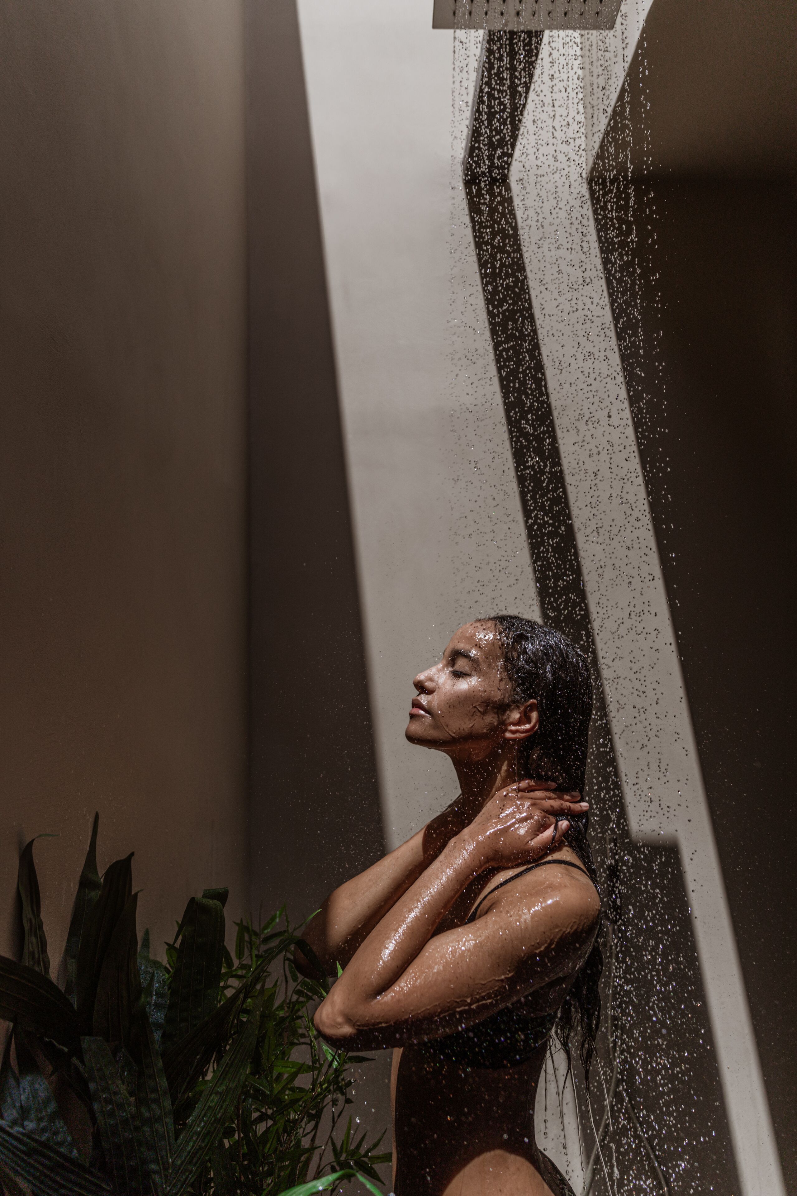 Una persona en la ducha, con gotas de agua visibles.
