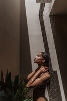 Una persona en la ducha, con gotas de agua visibles.