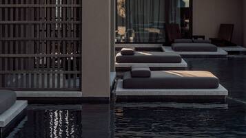Un área de piscina moderna con asientos escalonados y una pérgola de madera.