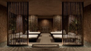 A spa area with two massage tables, a stone floor, and a bamboo partition. - Casa Cook Samos (Samos)