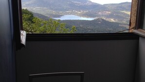 A room with a window overlooking a mountainous landscape and a lake. - Group offer T3**** + 5 rooms--> 15 people / private interior and garden (Speloncato)