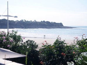 A beach with a view of the ocean and a distant landmass.