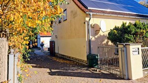 A building with a solar panel roof, a satellite dish, and a gated entrance.