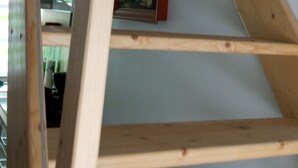 Una struttura a scala in legno in una stanza con un quadro appeso al muro.