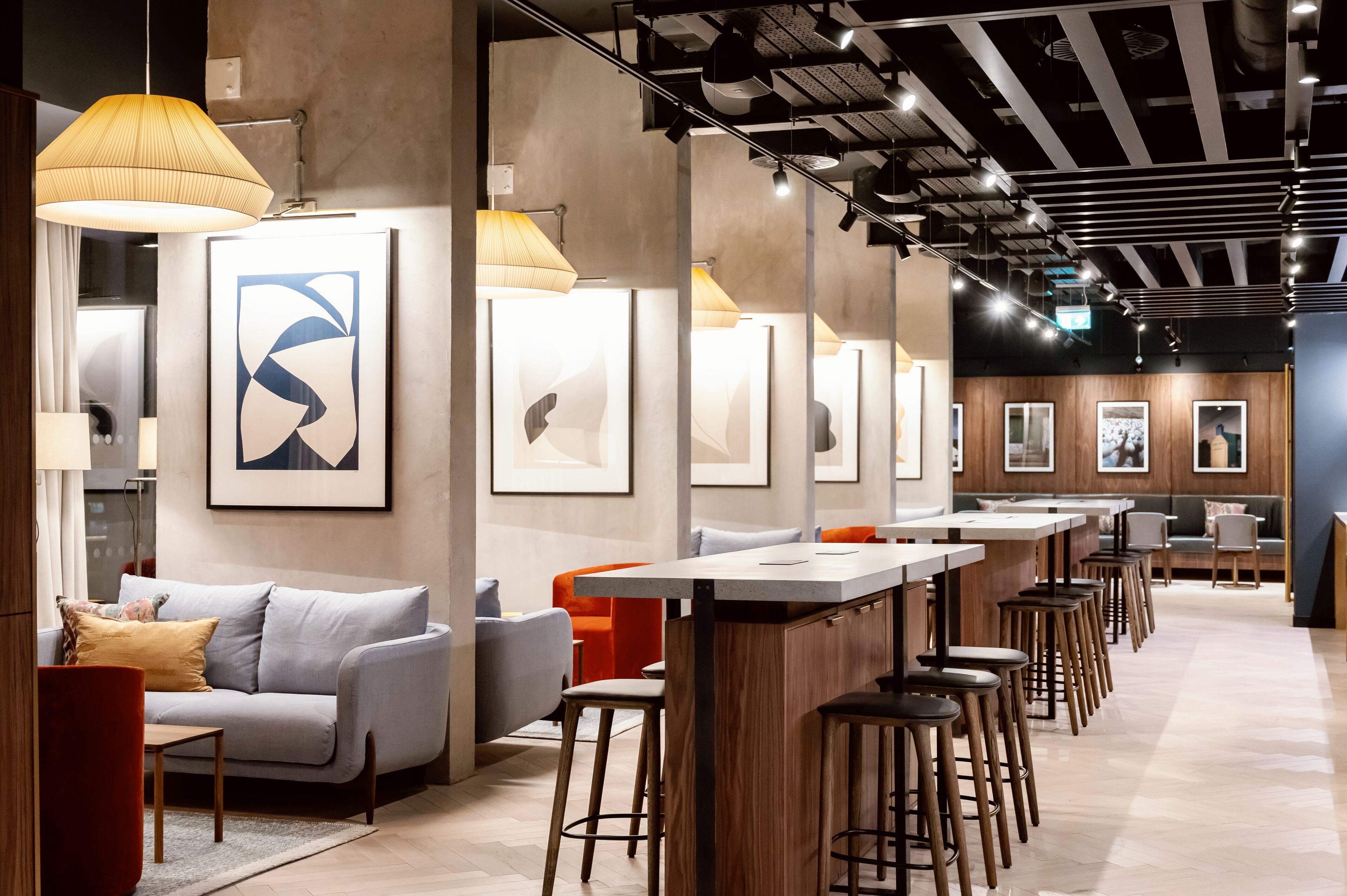 A modern interior with a bar area, seating, and artwork on the walls.