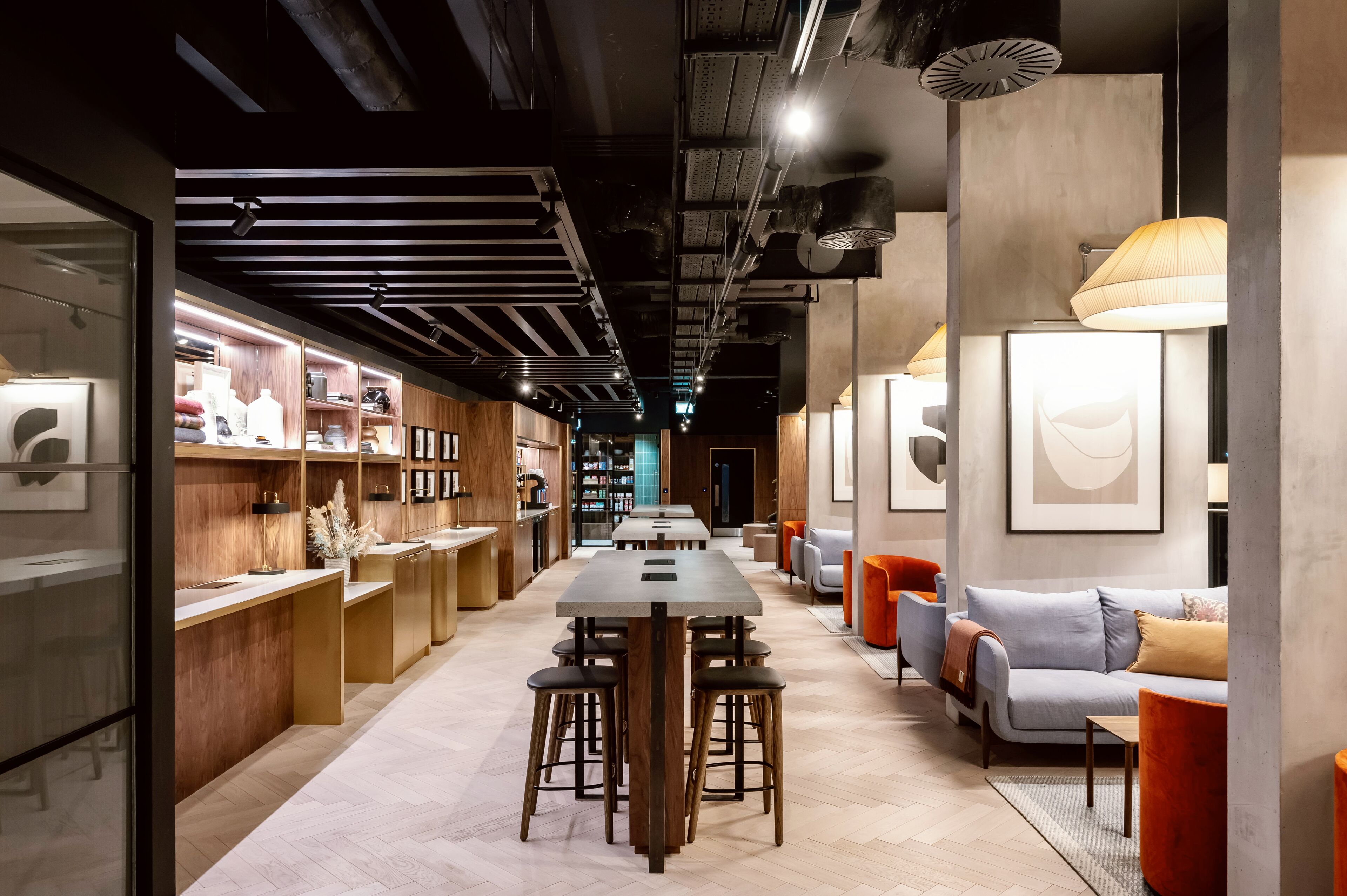 Een modern interieur met een lange eettafel, barstoelen en een zithoek met een bank en stoelen.