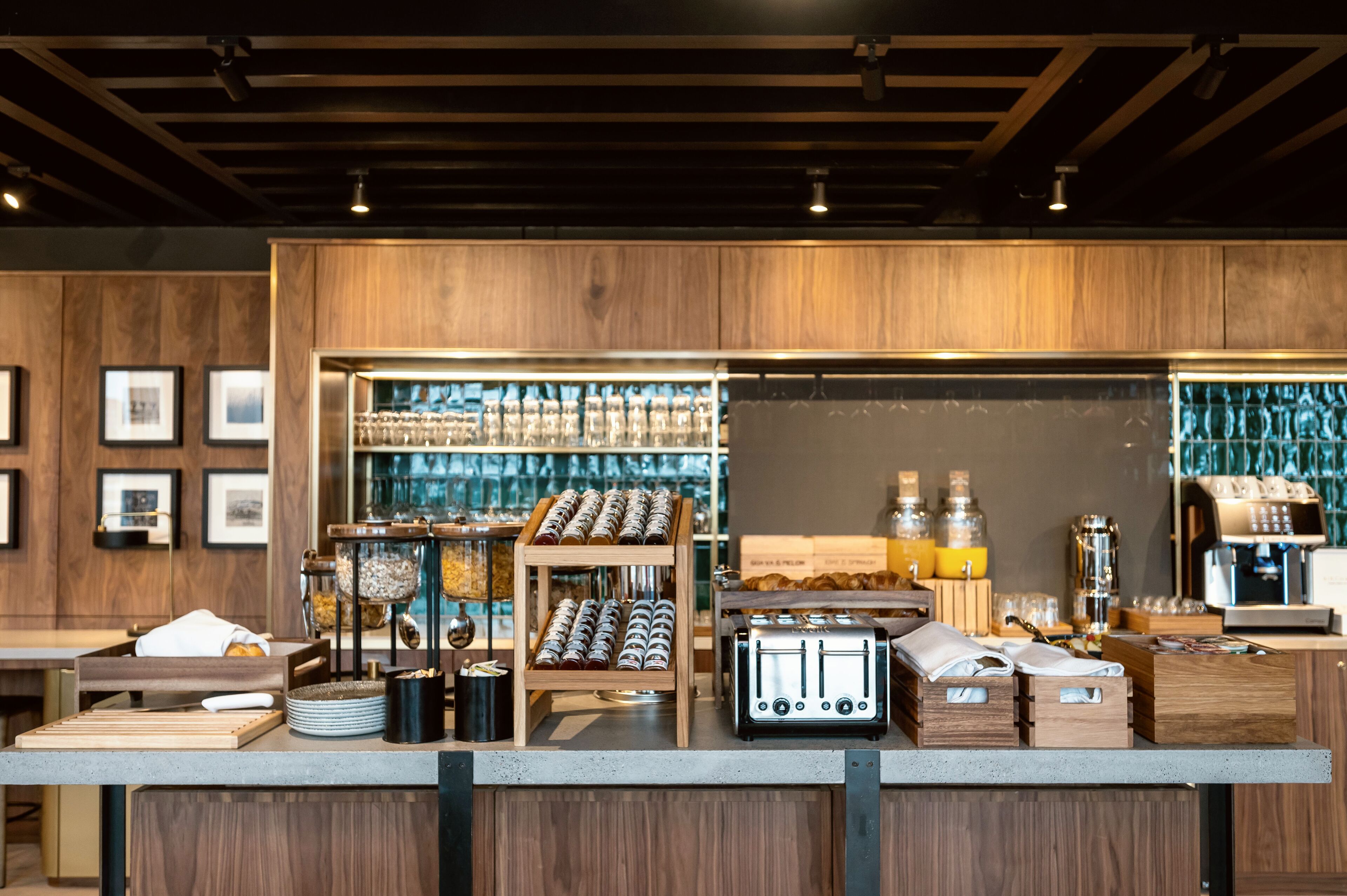 Una barra de café con una máquina de espresso, un tostador y diversos productos alimenticios.