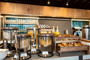 Un bufé de desayuno con diversos alimentos y recipientes.