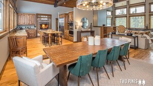 A spacious kitchen with wooden cabinets, a large island, and a fireplace. - Grand Estate! Ski-in/out, Hot Tub, 4 Fireplaces, Boot Dryer, Grill, 10m to Resor (Big Sky)