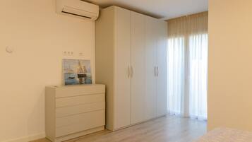 Une chambre à coucher avec un lit, une armoire, une commode et un tableau au mur.