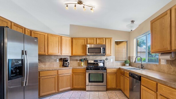 A kitchen with wooden cabinets, stainless steel appliances, a microwave, a stove, and a dishwasher. - Peaceful Valley - Rita Ranch/Tucson- 3BR/2BA/PrivatePool/NearShops&Restaurants (Tucson)