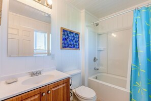 A bathroom with a white vanity, a toilet, a bathtub, and a shower curtain. - Lookout House - Discover Tranquility (Hope Town)
