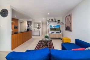 Relax in this stylish living space with a sofa, coffee table, and TV, plus a fully equipped kitchen with dining area.