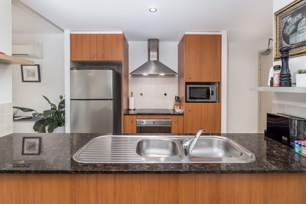 Enjoy cooking in this well-equipped kitchen with a refrigerator, oven, and sink.