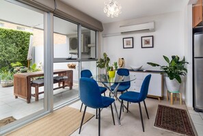 Enjoy meals at the glass dining table surrounded by comfortable chairs, with an outdoor area just steps away.