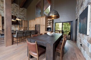Une cuisine spacieuse avec des meubles de rangement en bois, un grand îlot central doté de tabourets de bar et un luminaire suspendu.